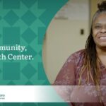 Woman with dark skin and long brown hair worn in braids wearing a floral blouse promotes the My Community, My Health Center campaign for the Community Health Centers of Benton & Linn Counties (CHC).