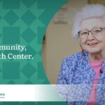 Woman with short white hair wearing glasses, a blue floral jacket, and a pink shirt promoting the My Community, My Health Center campaign for the Community Health Centers of Benton & Linn Counties (CHC).